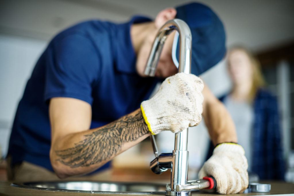 Plumber fixing kitchen sink