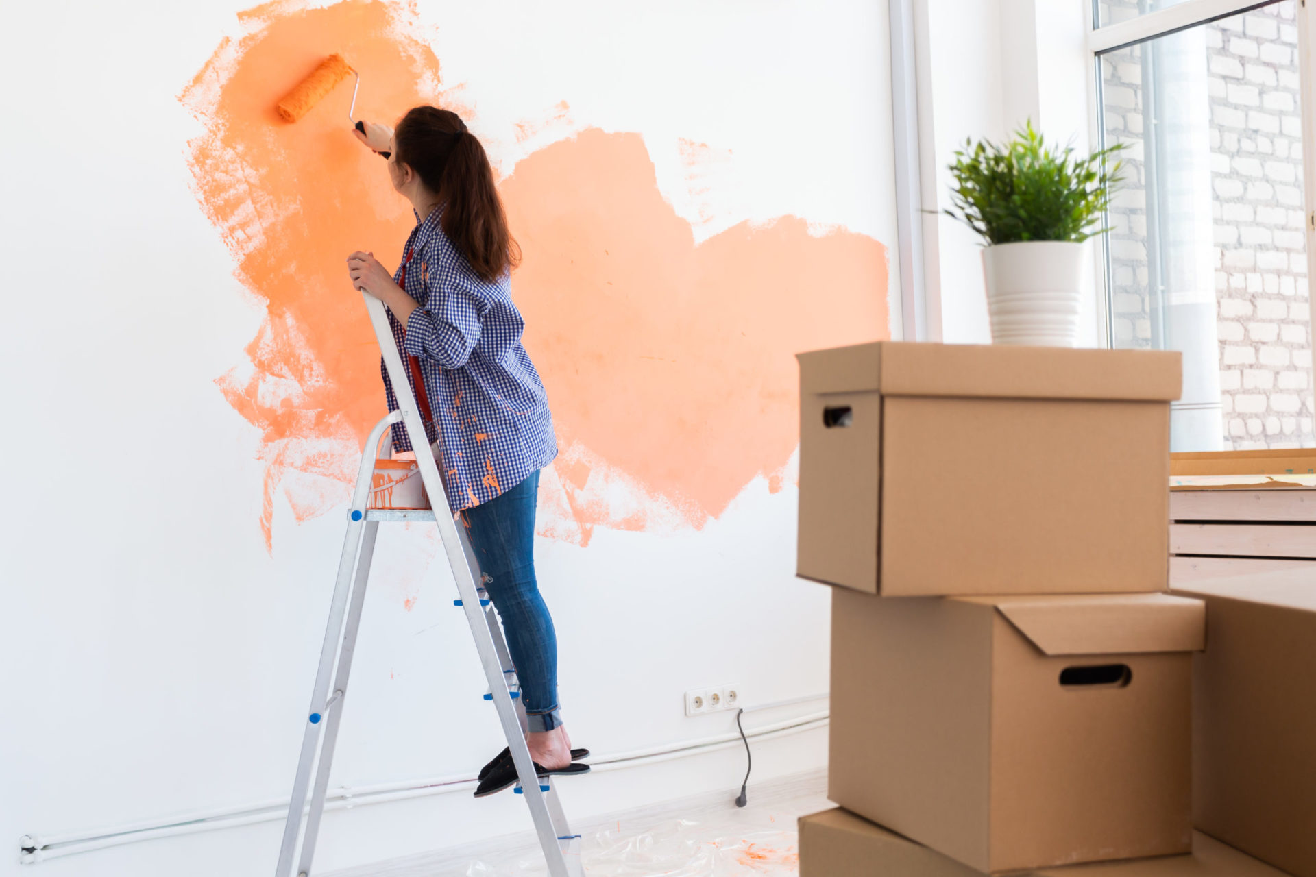 cheerful woman painting the walls of new home ren 2021 12 09 07 27 07 utc scaled