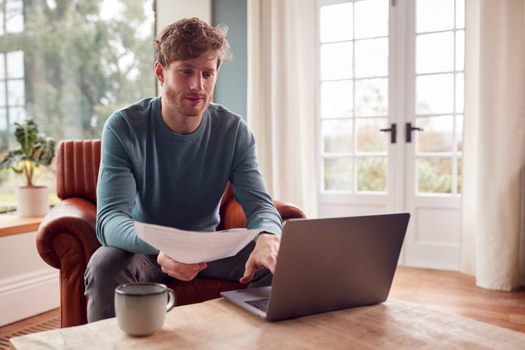 man sitting on armchair at home with laptop paying 2022 04 04 21 34 37 utc scaled